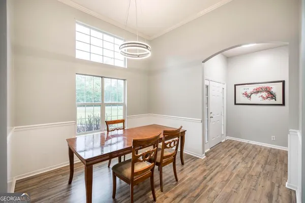 a view of a dining room with furniture a chandelier and wooden floor