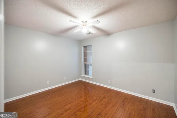 a view of an empty room with wooden floor