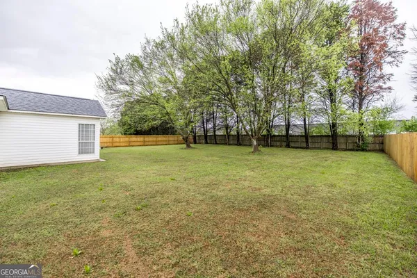 a view of a field with a trees in the background