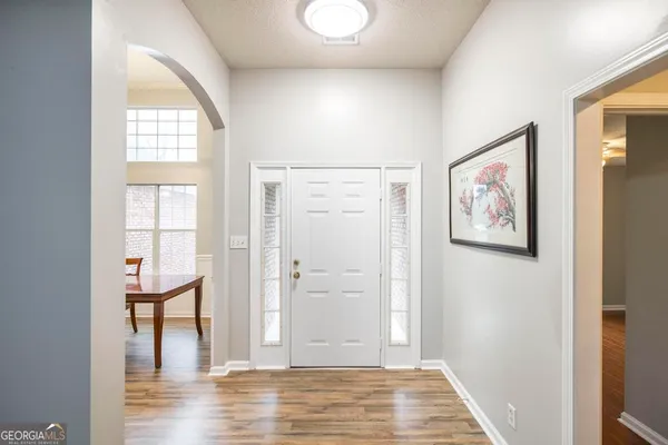a view of a hallway with wooden floor and windows