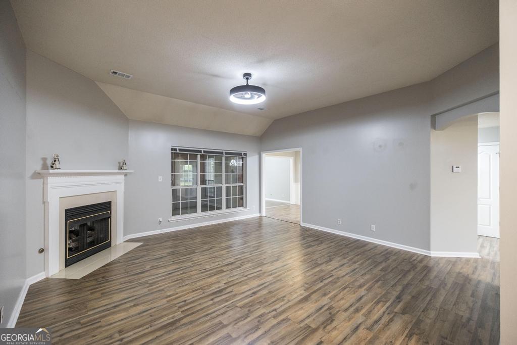 319 Smithville Church Road Warner Robins, GA 31088 - Photo 8 of 34 an empty room with wooden floor fireplace and windows