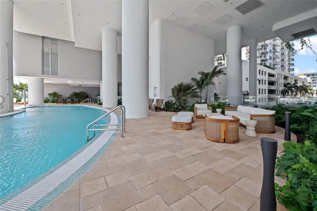 a dining room with furniture and a floor to ceiling window