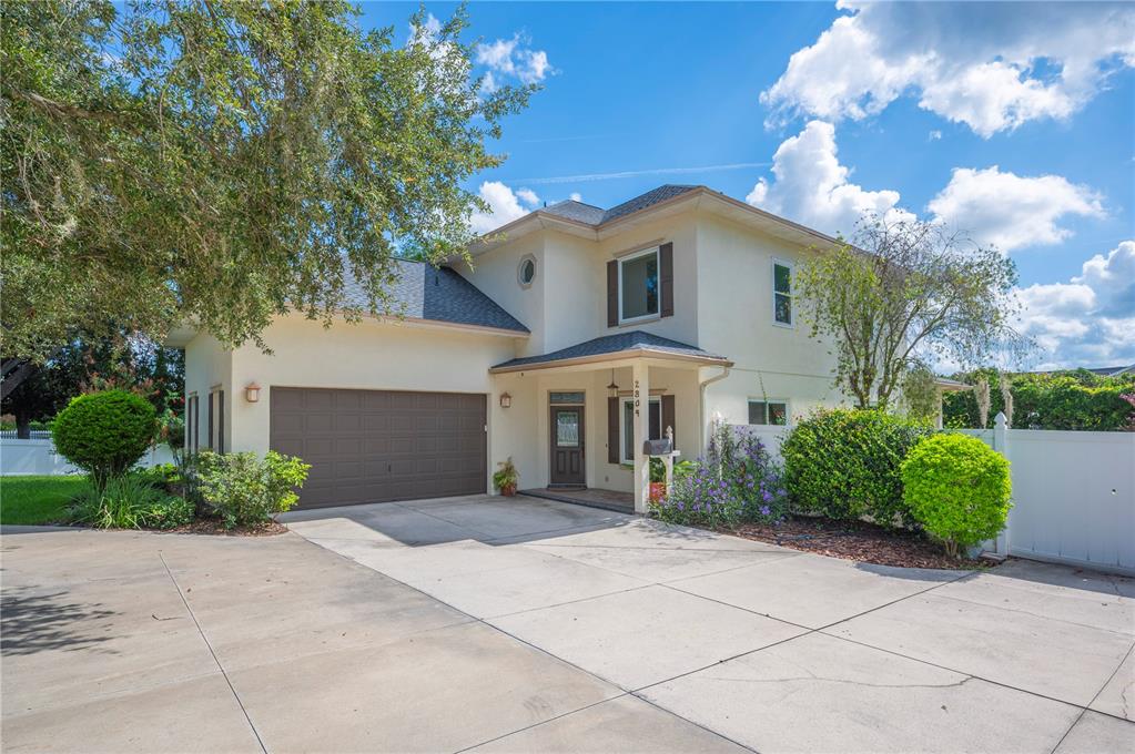 a view of a white house with a yard and potted plants