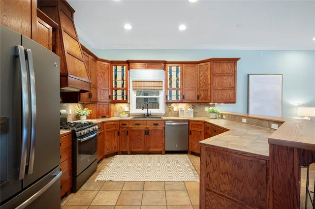 a kitchen with stainless steel appliances granite countertop a stove a sink and a refrigerator