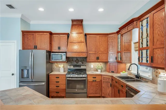 a kitchen with stainless steel appliances granite countertop a stove sink and cabinets