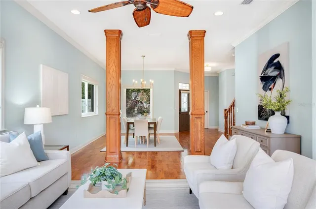 a dining room with wooden floor a chandelier a glass table and chairs