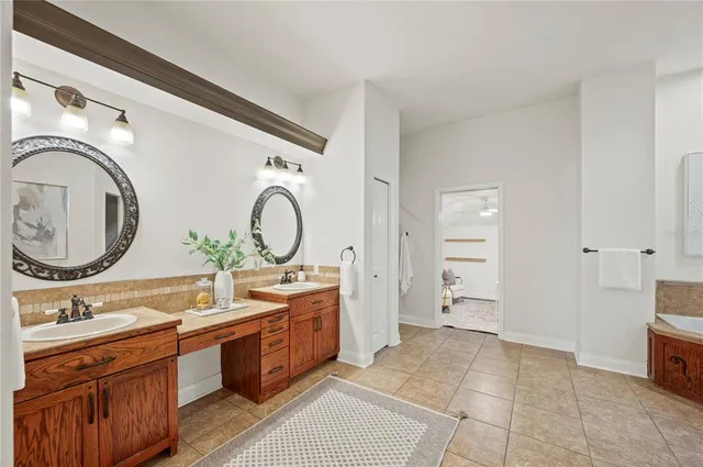a spacious bathroom with a tub sink and mirror