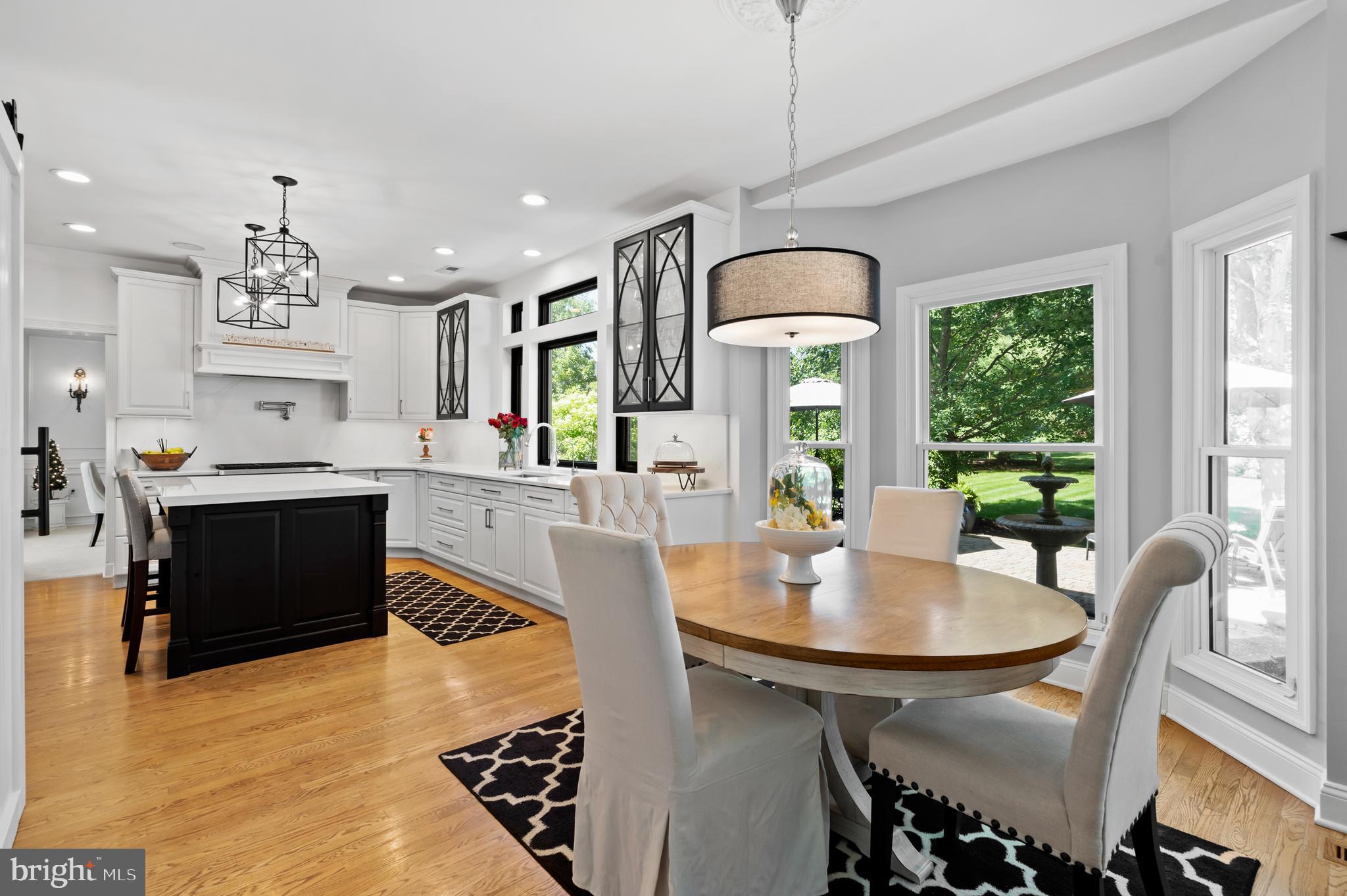 75 Bittersweet Drive Doylestown, PA 18901 - Photo 20 of 65 a kitchen with kitchen island granite countertop a stove a refrigerator a dining table and chairs with a large window