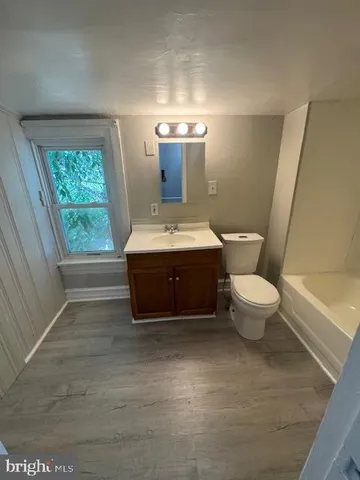 a bathroom with a sink toilet and window
