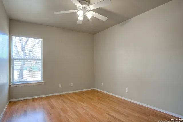an empty room with a window and wooden floor