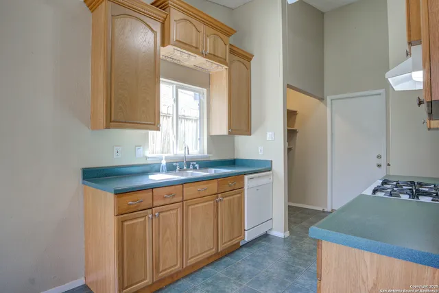 a kitchen with granite countertop a sink and cabinets