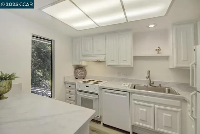 a kitchen with stainless steel appliances white cabinets and a sink