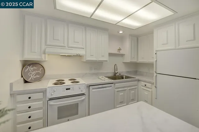 a kitchen with cabinets appliances a sink and a counter top space