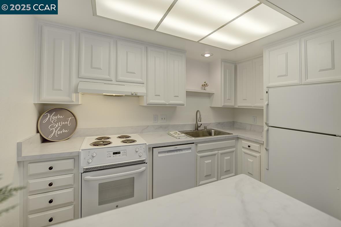 1333 Singingwood Court, Unit 1 Walnut Creek, CA 94595 - Photo 8 of 34 a kitchen with cabinets appliances a sink and a counter top space