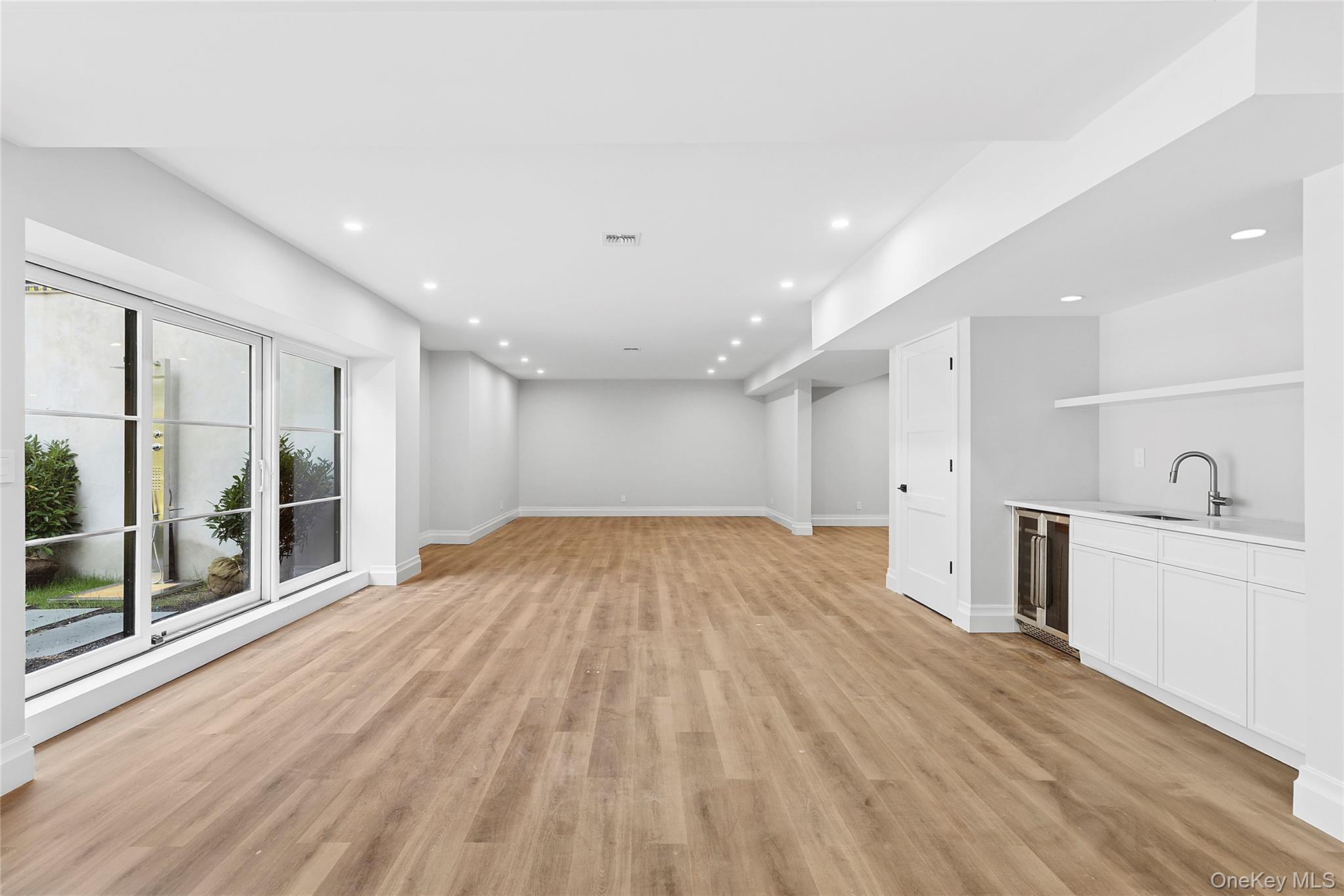 3360 Wunneweta Road Cutchogue, NY 11935 - Photo 26 of 32 Unfurnished living room with light wood finished floors, recessed lighting, and beverage cooler