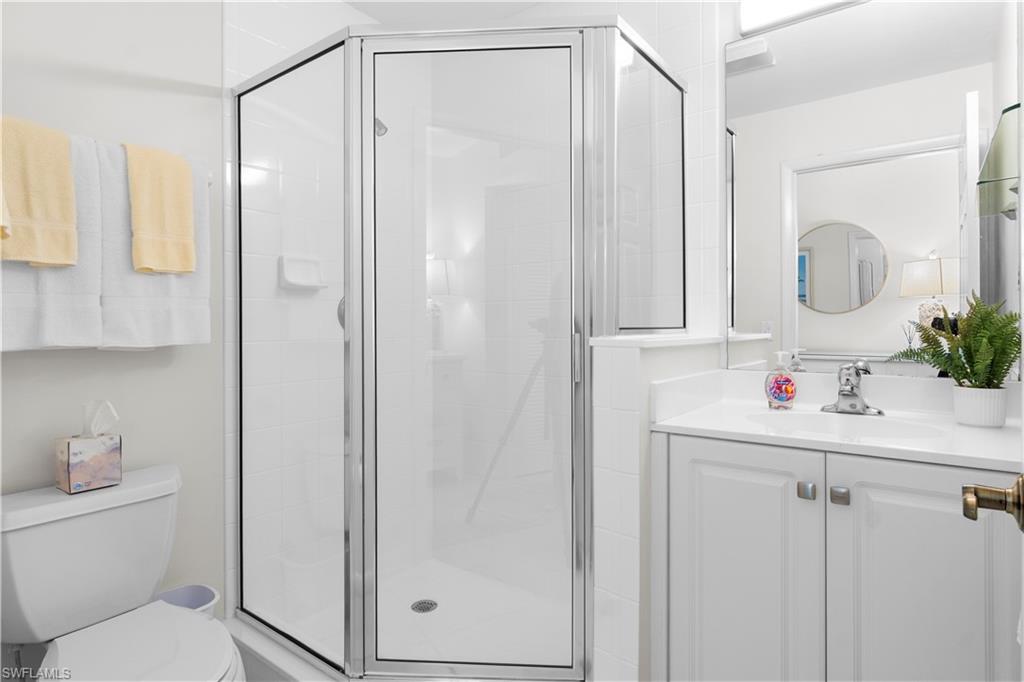 290 4th Street South, Unit 202 Naples, FL 34102 - Photo 12 of 21 a bathroom with a shower a sink and a mirror