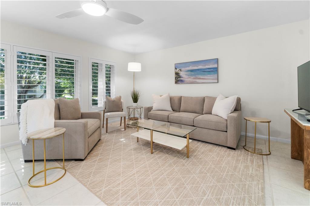 290 4th Street South, Unit 202 Naples, FL 34102 - Photo 4 of 21 a living room with furniture and a table