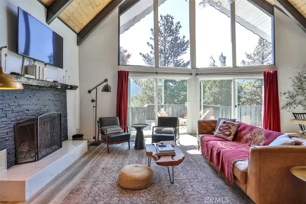 a living room with furniture a fireplace and a large window