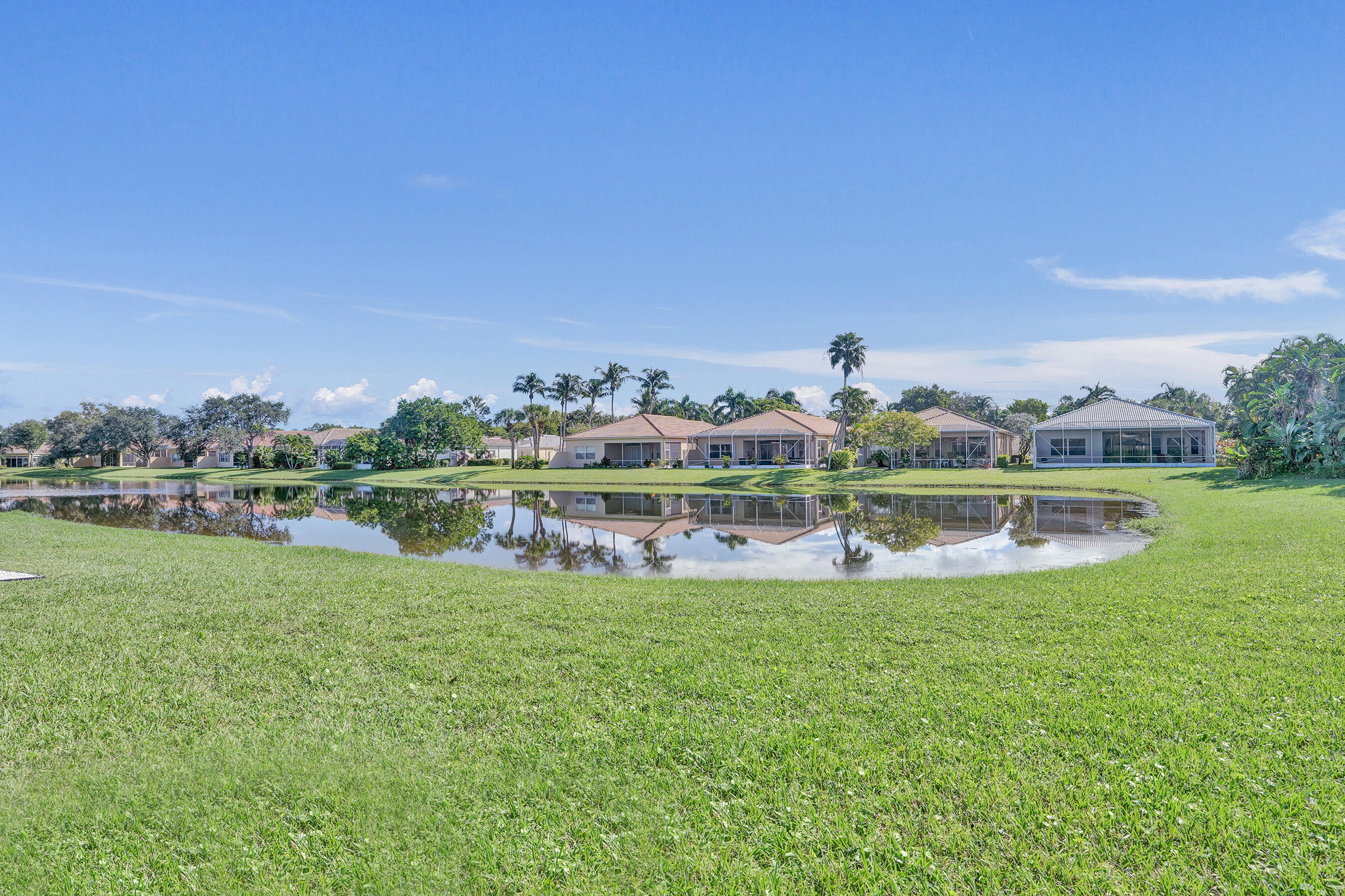15874 Vivanco Street Delray Beach, FL 33446 - Photo 25 of 33 a view of a lake with a big yard and large trees