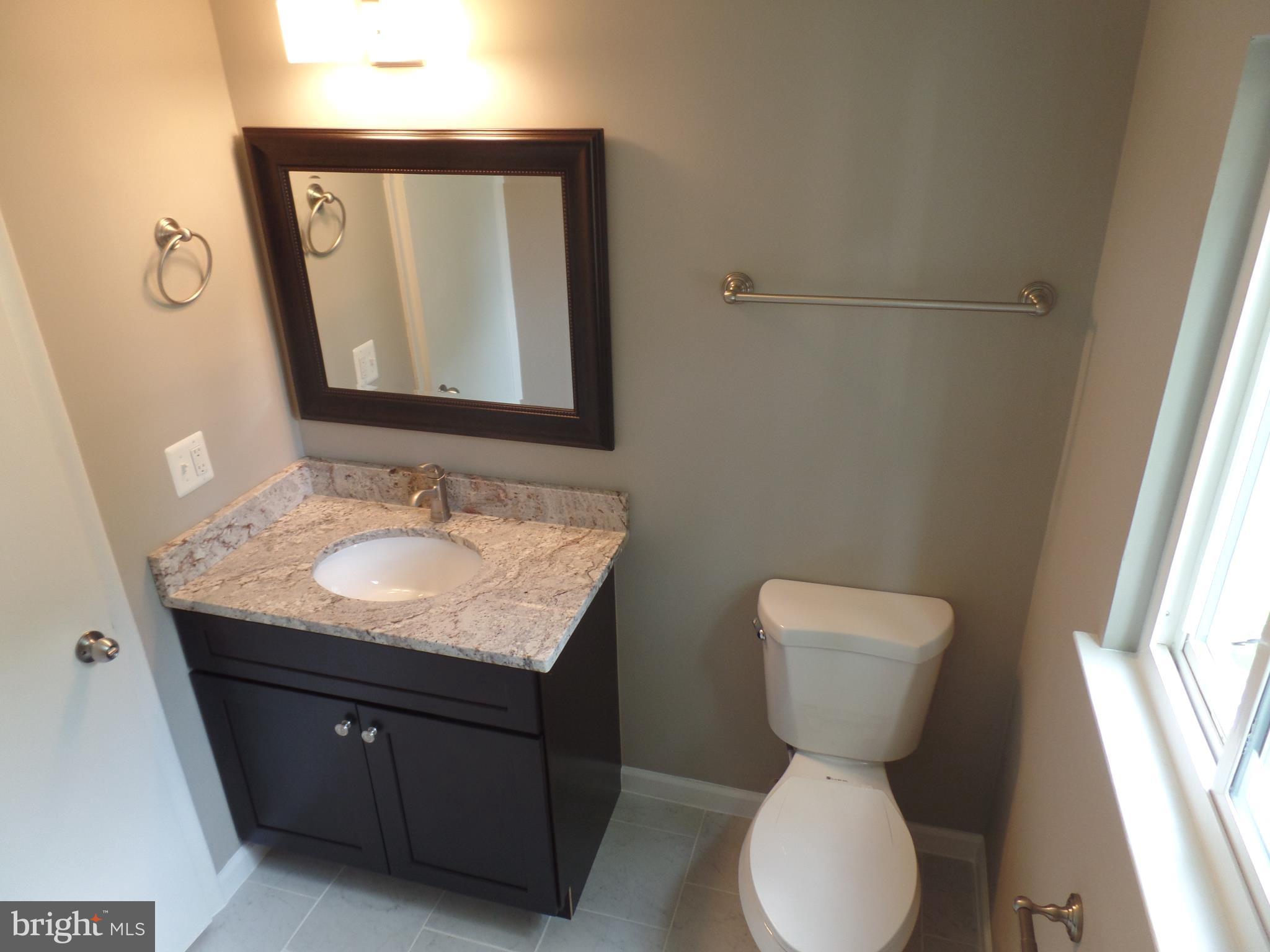 18940 Glendower Road Gaithersburg, MD 20879 - Photo 22 of 30 a bathroom with a granite countertop toilet sink and mirror