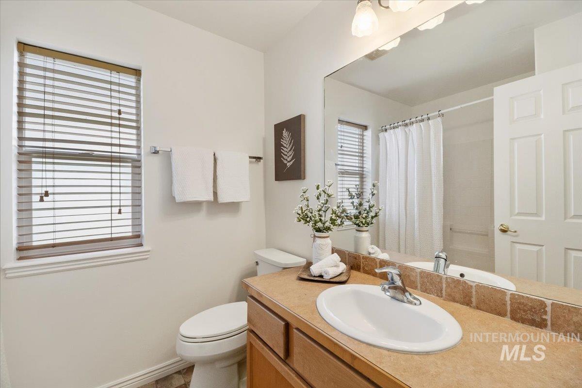 2032 Talus Loop Twin Falls, ID 83301 - Photo 26 of 43 Bathroom featuring an integrated sink vanity, tile backsplash, and a window with blinds