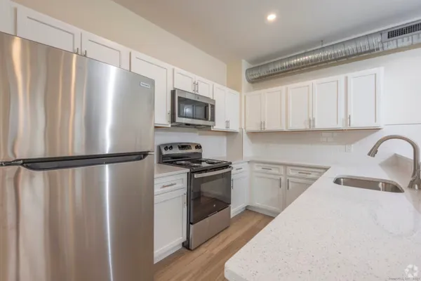 a kitchen with stainless steel appliances a refrigerator sink and white cabinets