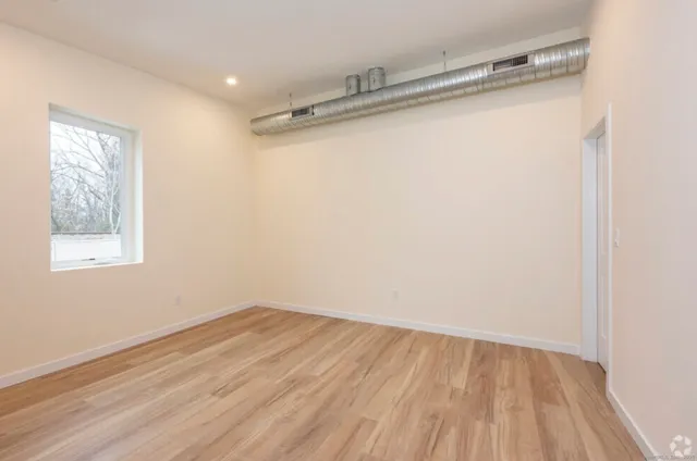 a view of a room with wooden floor and white walls