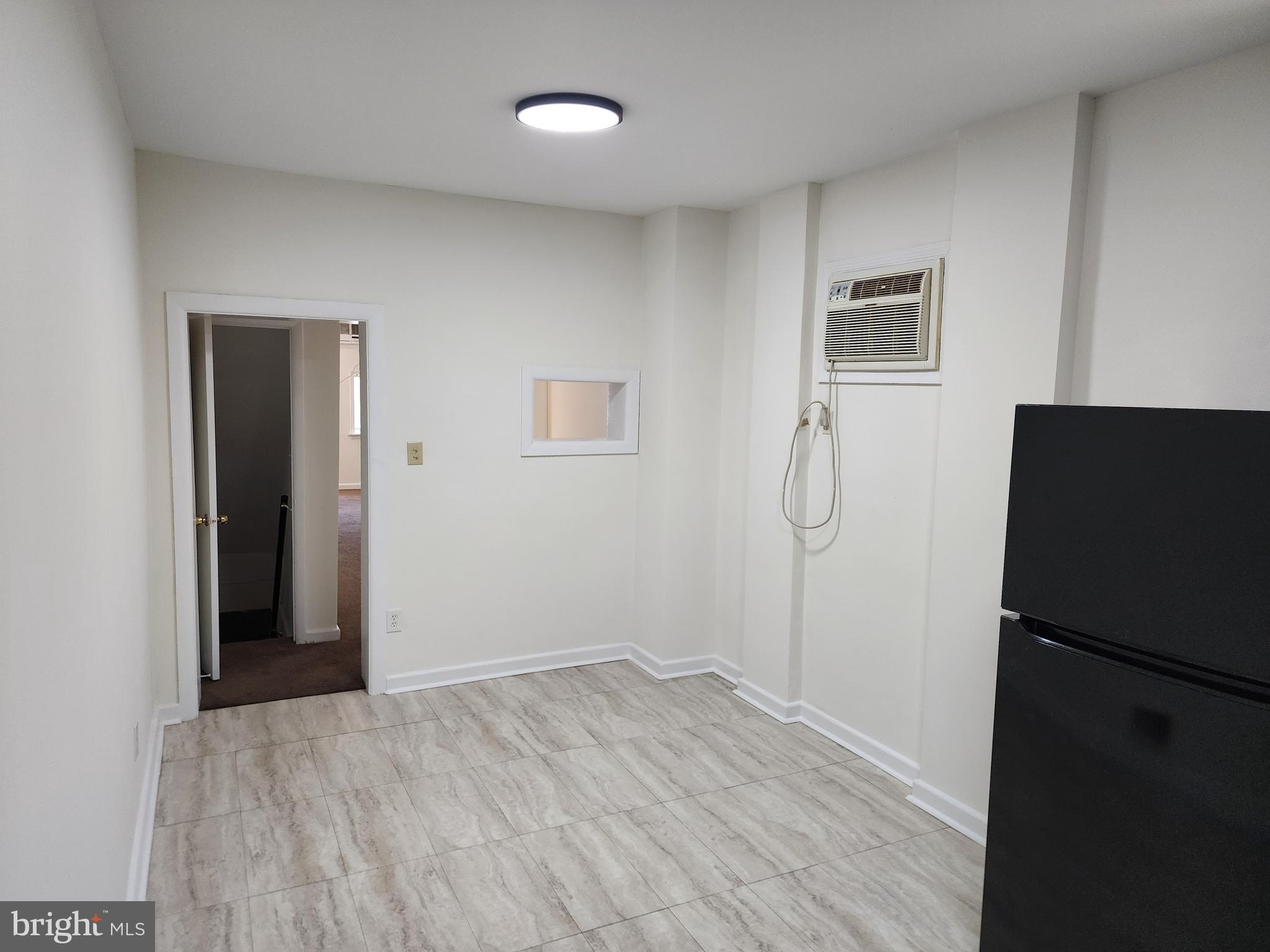 304 North 64th Street Philadelphia, PA 19139 - Photo 12 of 36 a view of an empty room with wooden floor and a refrigerator