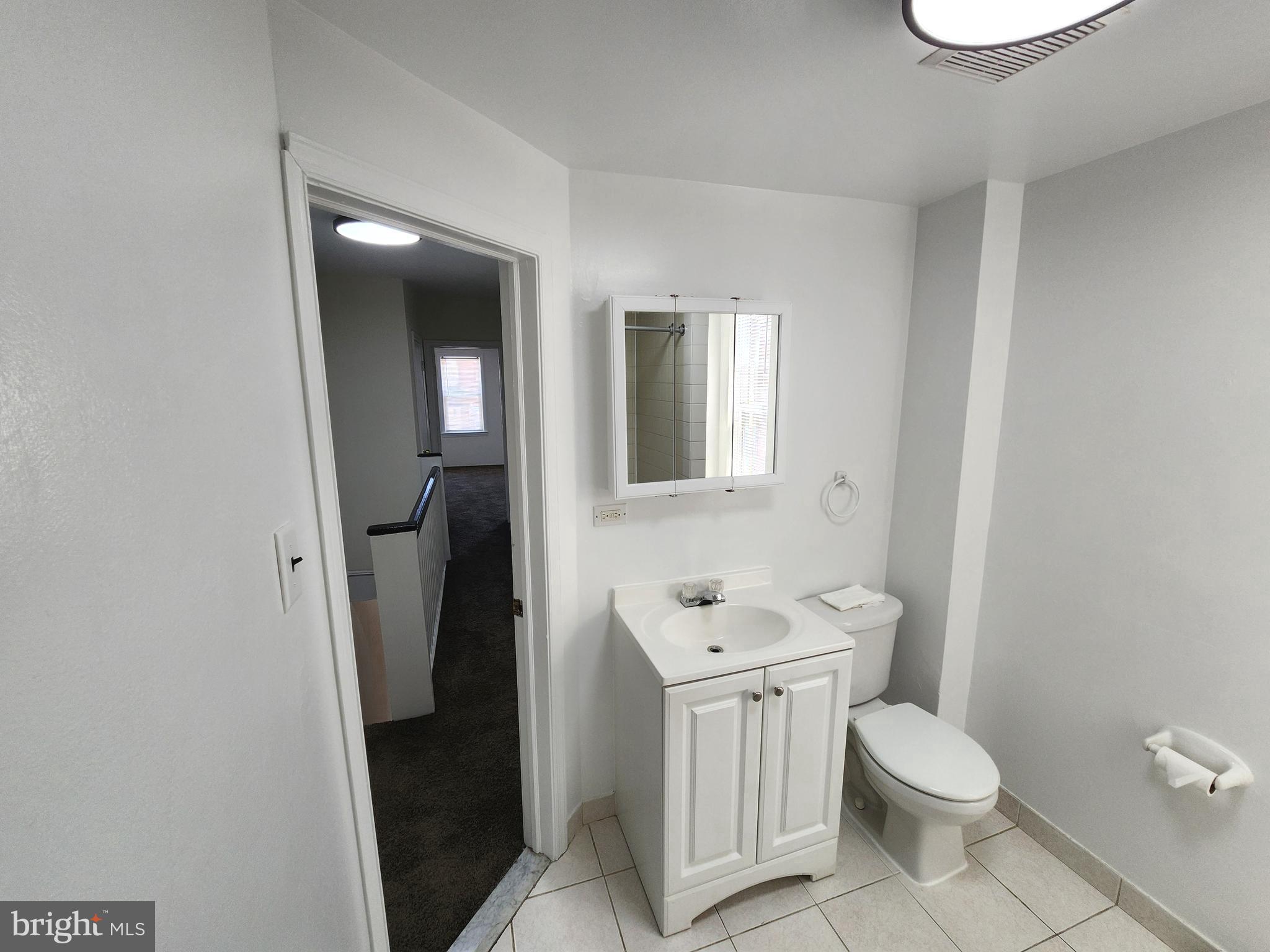 304 North 64th Street Philadelphia, PA 19139 - Photo 24 of 36 a bathroom with a toilet sink and mirror