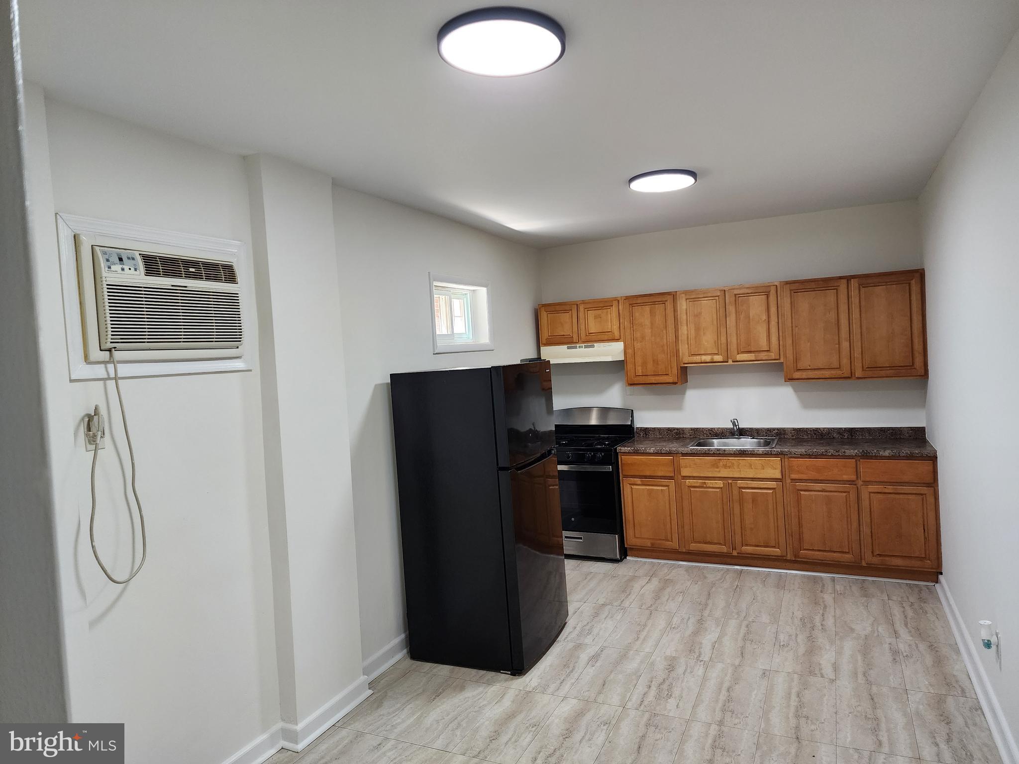 304 North 64th Street Philadelphia, PA 19139 - Photo 9 of 36 a kitchen with stainless steel appliances granite countertop a refrigerator a stove top oven a sink and dishwasher
