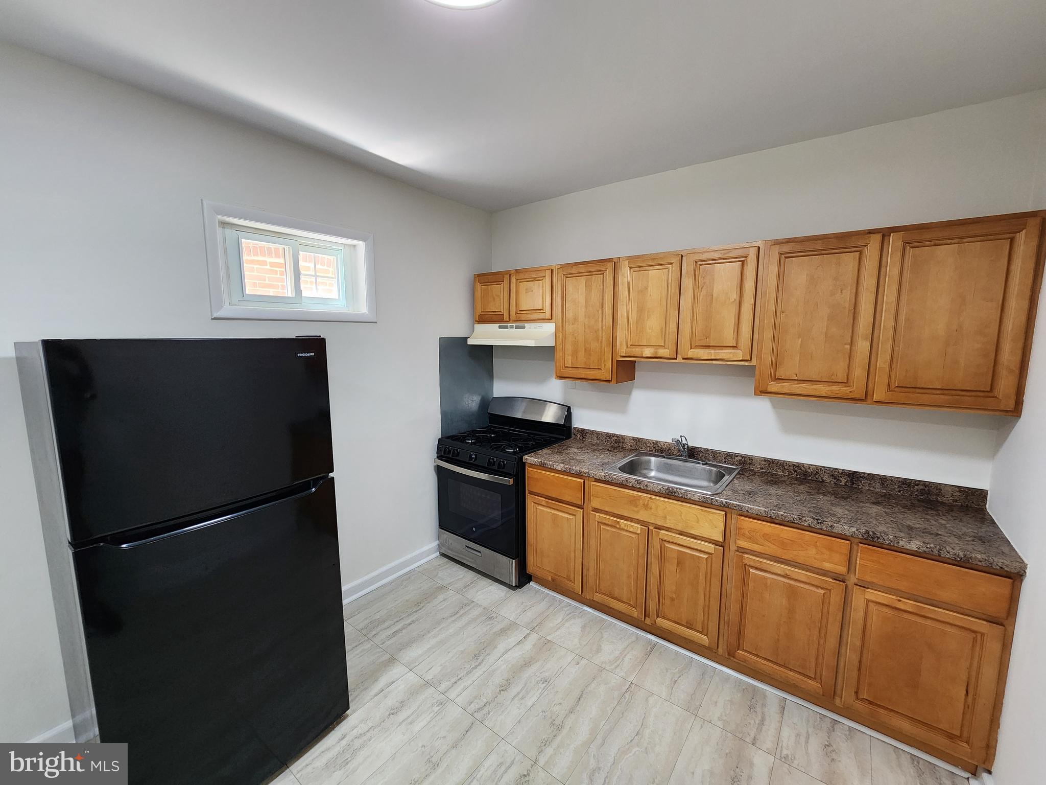 304 North 64th Street Philadelphia, PA 19139 - Photo 10 of 36 a kitchen with granite countertop stainless steel appliances a refrigerator a sink a stove a microwave and cabinets