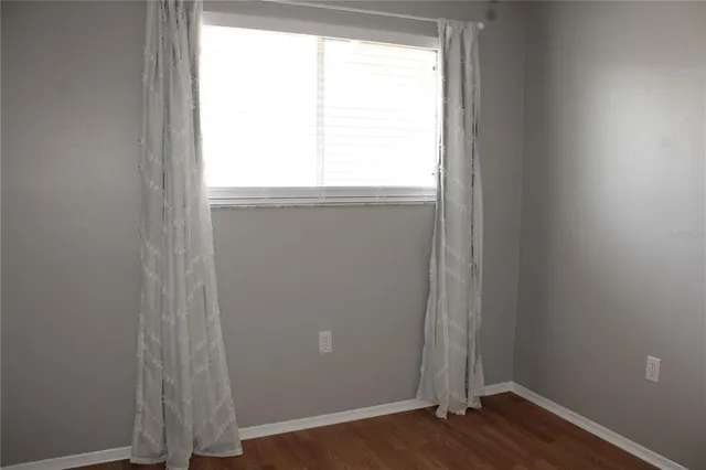 an empty room with wooden floor and entrance
