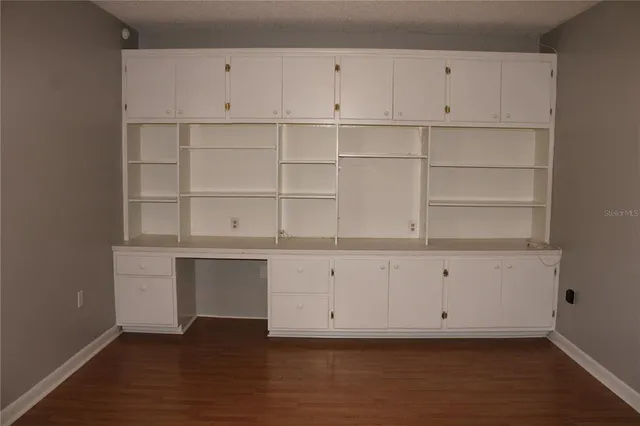 a view of an empty room with cabinet and a window