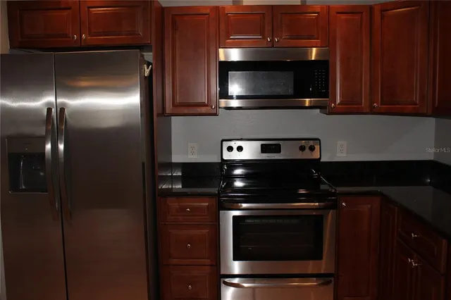 a kitchen with stainless steel appliances granite countertop a stove and a microwave