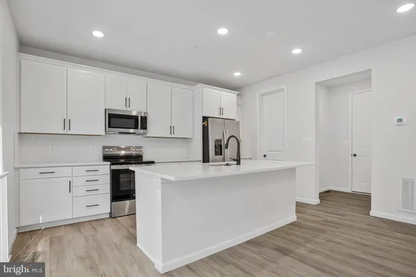 a kitchen with stainless steel appliances a sink stove and cabinets