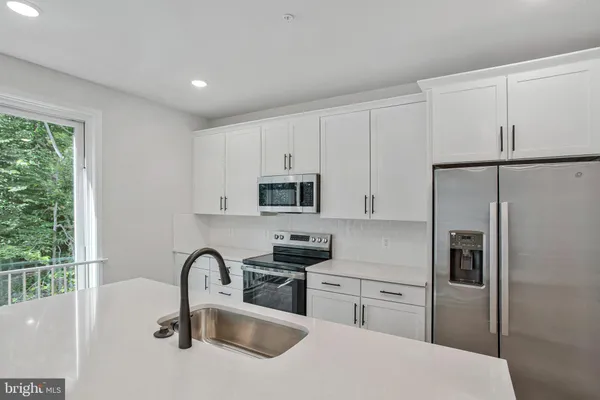 a kitchen with a refrigerator sink and cabinets