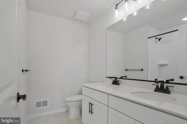 a bathroom with a sink a toilet and a mirror