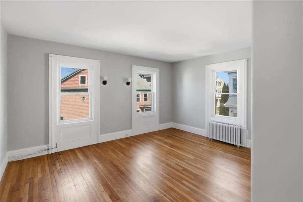 199 Purchase Street, Unit 2 Fall River, MA 02720 - Photo 3 of 10 an empty room with wooden floor and windows
