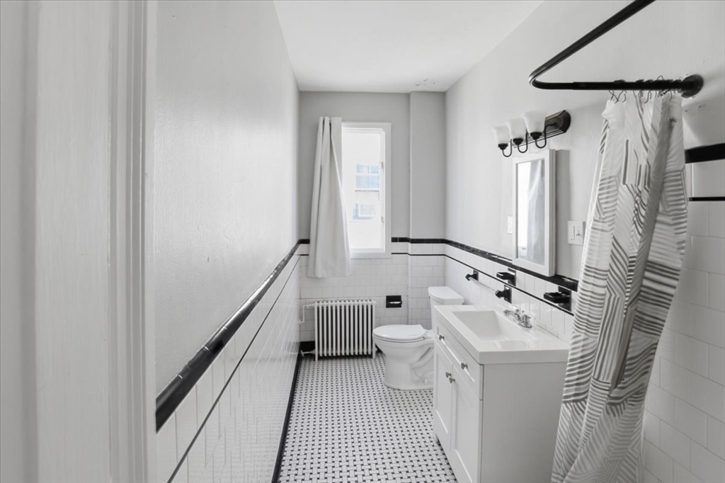 199 Purchase Street, Unit 2 Fall River, MA 02720 - Photo 6 of 10 a bathroom with a sink a toilet and a mirror