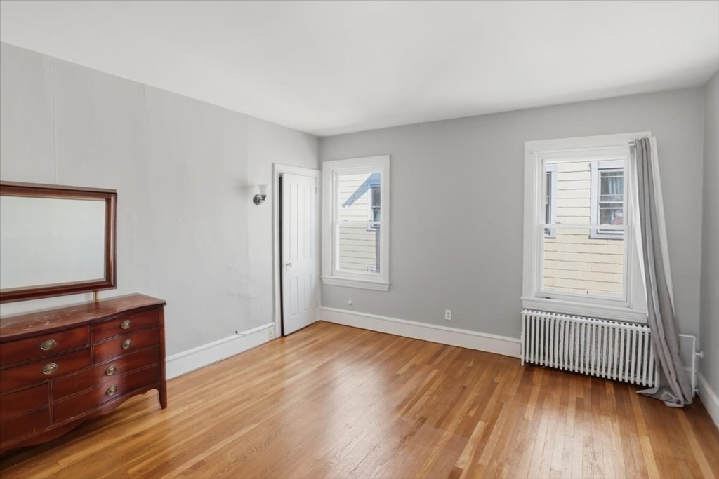 199 Purchase Street, Unit 2 Fall River, MA 02720 - Photo 9 of 10 a view of an empty room with wooden floor and a window