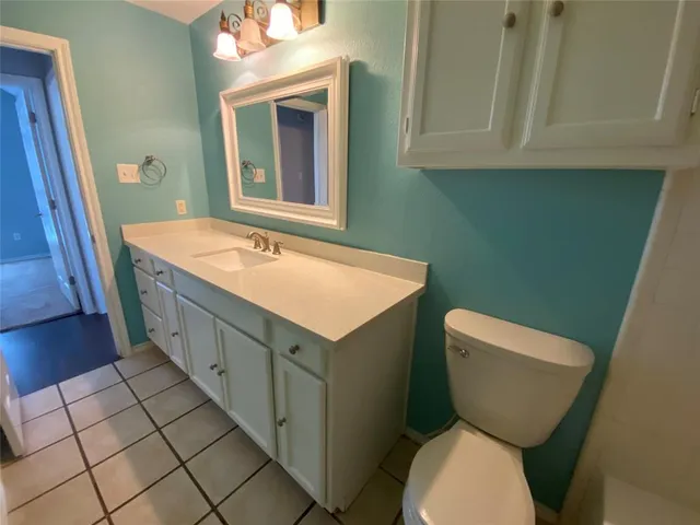 a bathroom with a granite countertop toilet sink and mirror