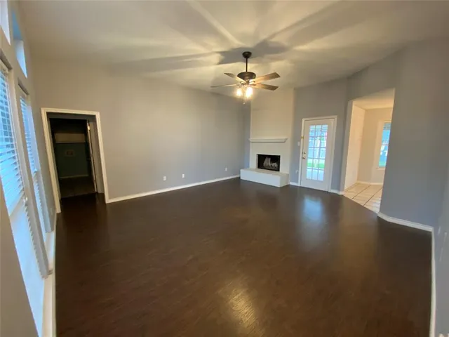 an empty room with windows and fireplace