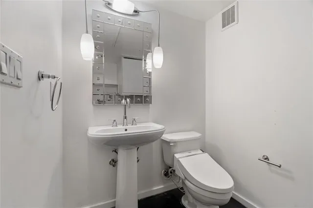 a bathroom with a toilet sink and mirror