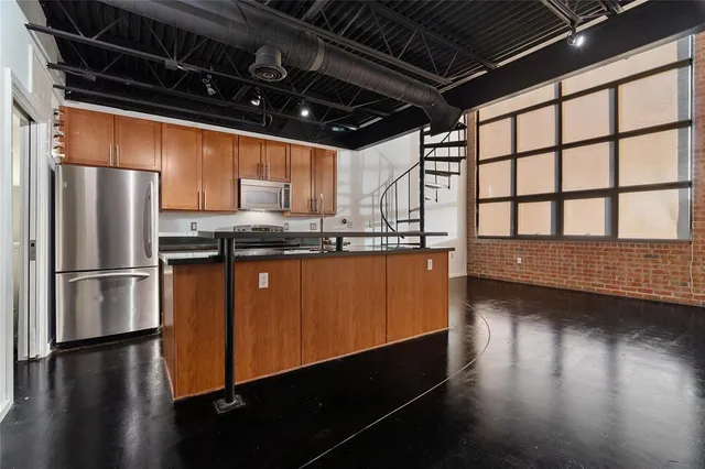 a kitchen with stainless steel appliances granite countertop a refrigerator a sink and a stove