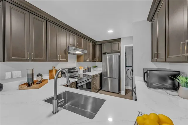 a kitchen with stainless steel appliances granite countertop a refrigerator and a sink