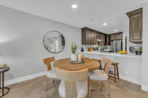 a kitchen with a dining table chairs and a refrigerator