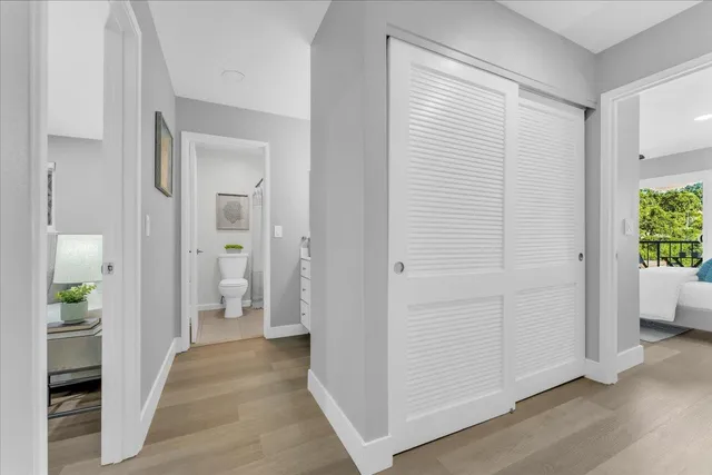 a view of a hallway with bathroom and wooden floor