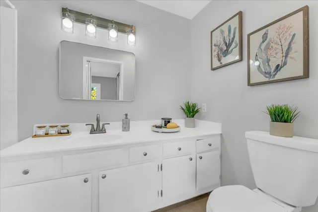 a bathroom with a toilet sink and mirror
