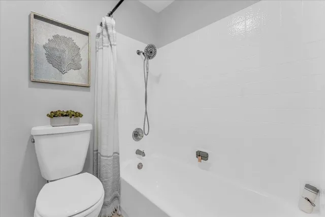 a white toilet sitting next to a bath tub shower