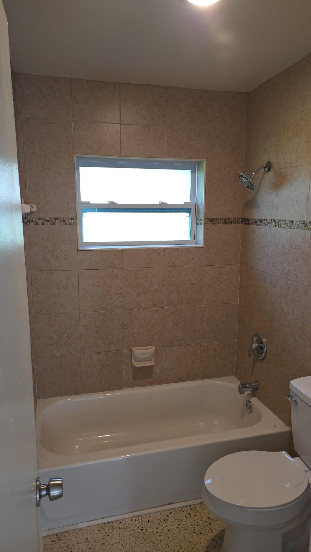 2736 Seneca Avenue Fort Pierce, FL 34946 - Photo 15 of 16 a bath tub sitting next to a white toilet
